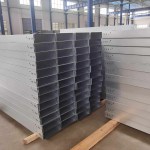 Uma pilha de calhas de cabos com acabamento preciso, exibindo os característicos trilhos laterais, aberturas de ventilação e bordas lisas, prontas para instalação em ambientes industriais ou comerciais.