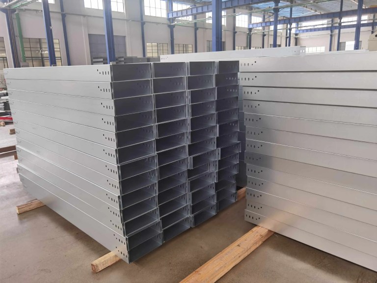 Uma pilha de calhas de cabos com acabamento preciso, exibindo os característicos trilhos laterais, aberturas de ventilação e bordas lisas, prontas para instalação em ambientes industriais ou comerciais.