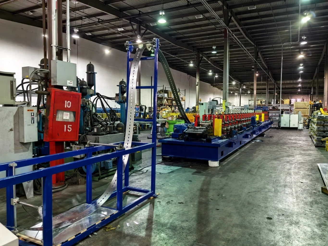 Roll forming feeder guiding strip into forming rollers.