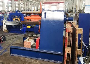 Eine robuste industrielle hydraulische Abwickelvorrichtung hält eine große Stahlcoil, die den Ausgangspunkt des Walzformprozesses markiert.