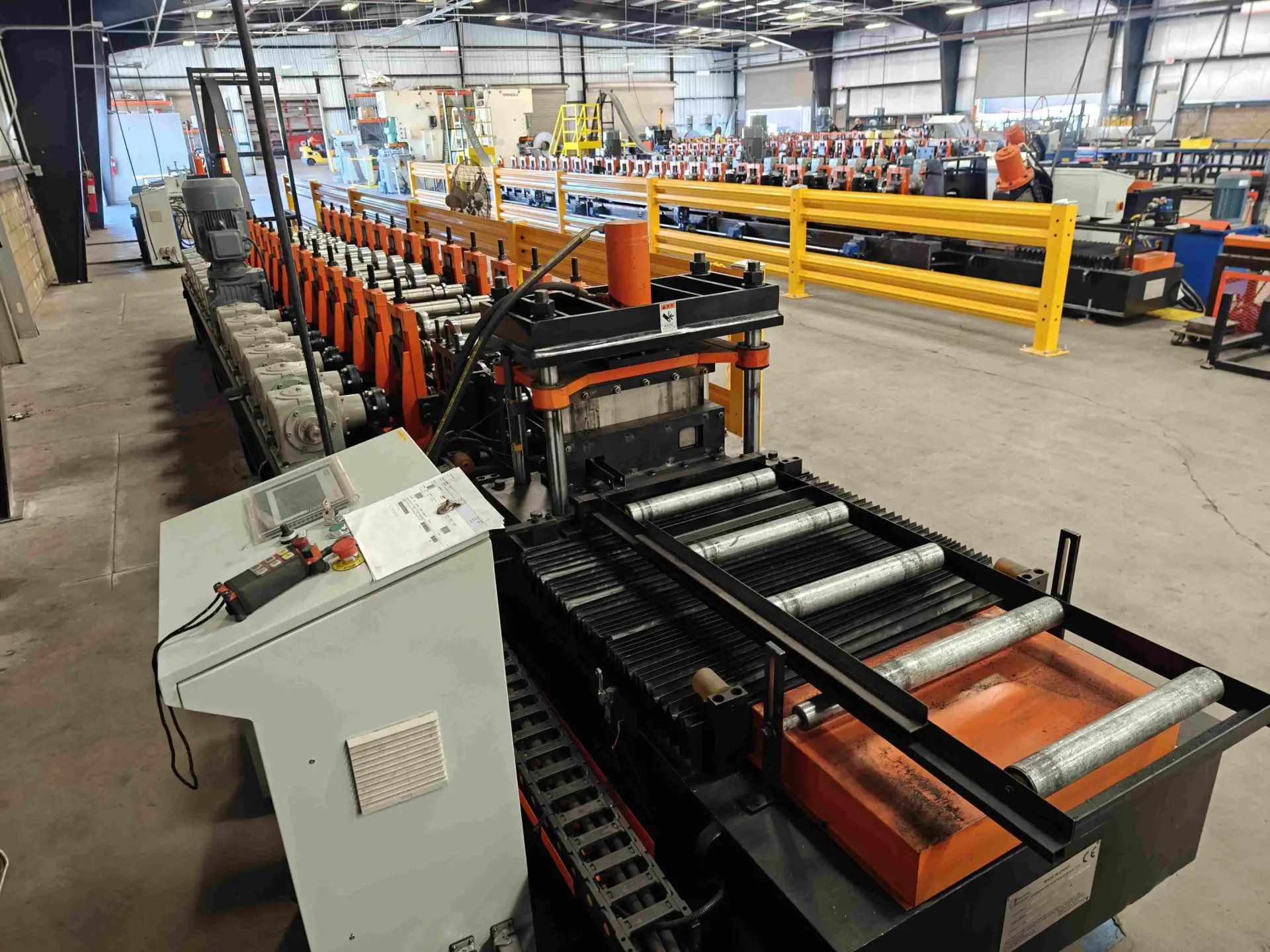 Ein fliegender Hydraulikschneider zerschneidet das fertige C-Verstrebungsprofil, während die Maschine mit hoher Geschwindigkeit läuft.