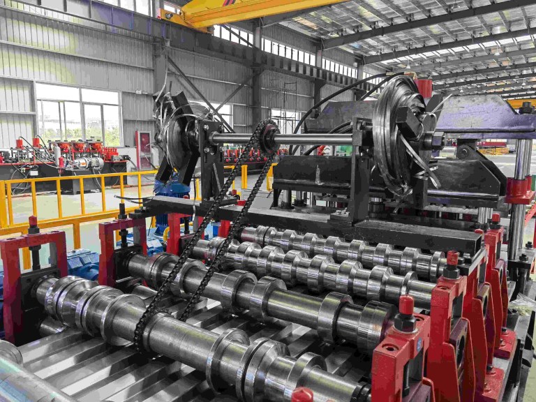 Крупный план роликов на профилегибочной машине для производства стеновых панелей для сверхпрочных контейнеров.