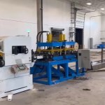 Gros plan sur le servo-alimentateur et le dispositif de poinçonnage hydraulique d'une machine de profilage de pannes Sigma.