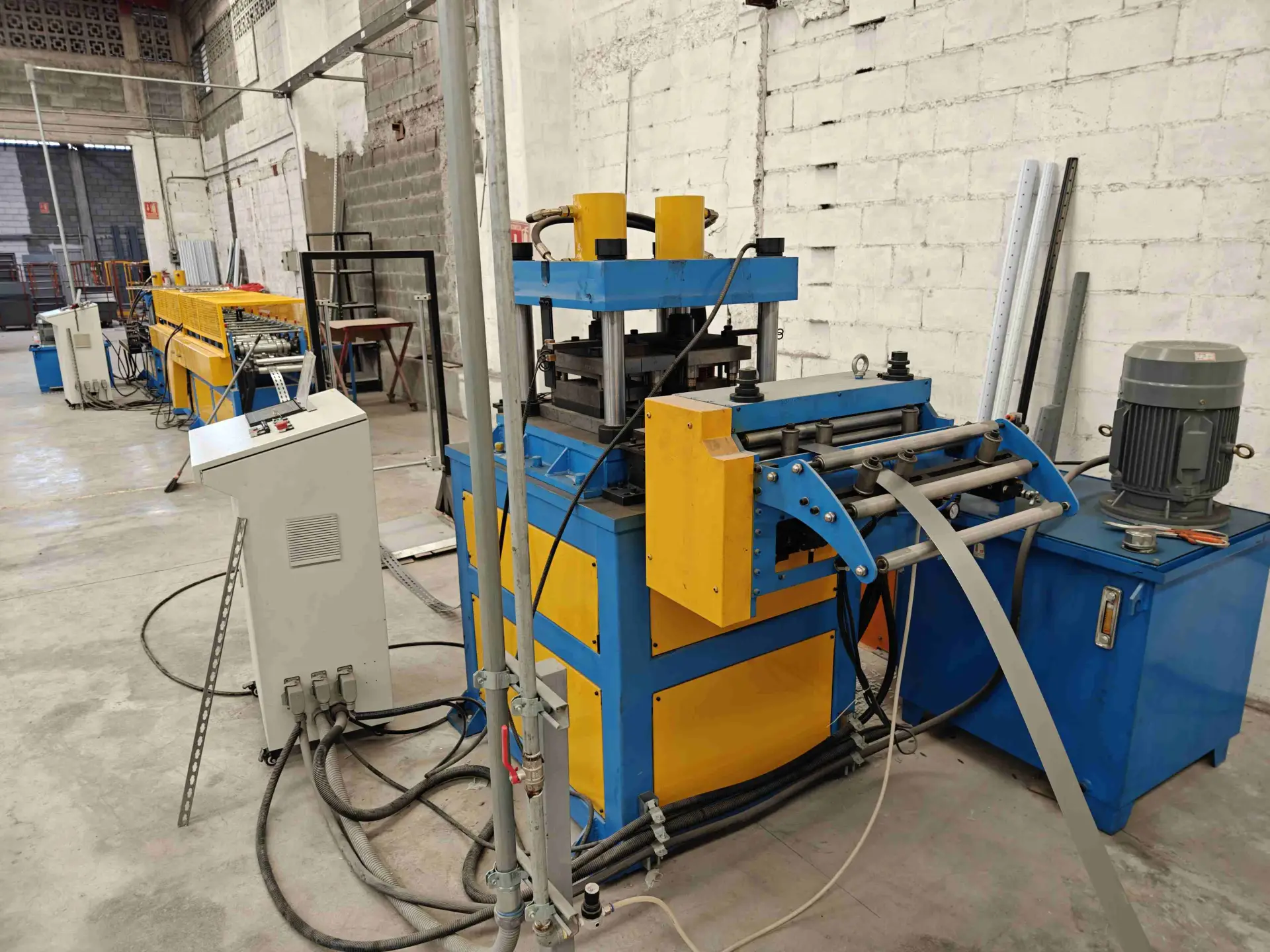 Nahaufnahme des Servo-Zuführers und der hydraulischen Stanzvorrichtung, die präzise Löcher in den Metallstreifen erzeugen.