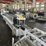 Un mécanisme de coupe hydraulique robuste (cisaille) positionné à l'extrémité de la ligne de profilage, prêt à couper avec précision le profilé de rail DIN formé en continu aux longueurs finies requises.